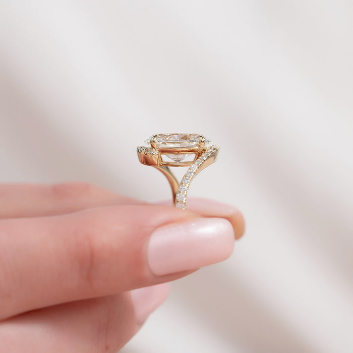 Side profile of oval moissanite bypass halo ring showing pave split band