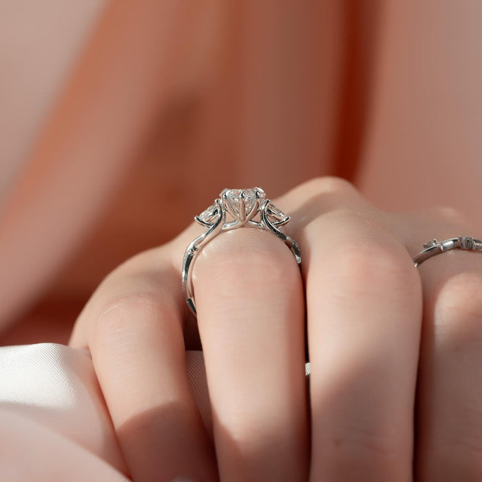 Pear cut moissanite three stone vine band ring in 14K white gold on finger