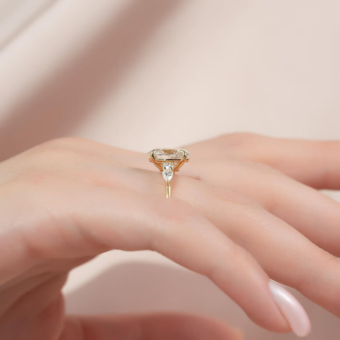 Side view of oval moissanite three stone ring with pear accents