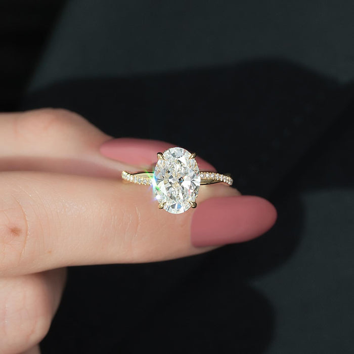 Oval moissanite pave hidden halo ring sparkling on fingertip