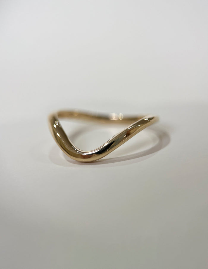 Slim plain gold wave wedding band, angled view