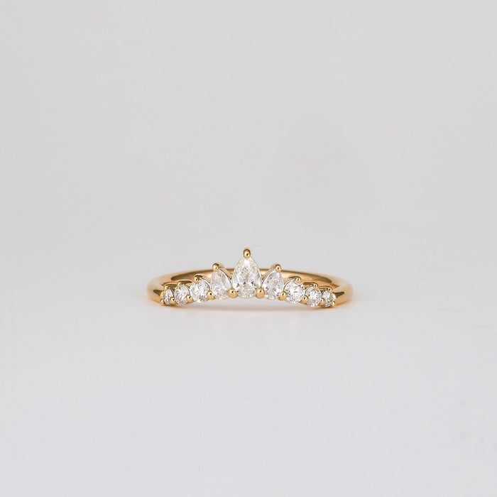 Front view of a pear and round moissanite curved band in yellow gold