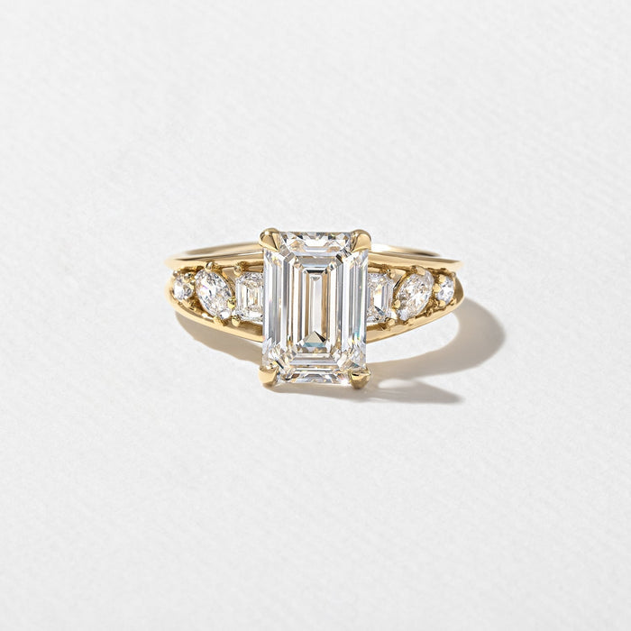 Emerald cut lab grown diamond ring with cluster set shoulders in yellow gold