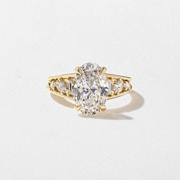 Oval cut lab grown diamond ring with cluster set shoulders in yellow gold