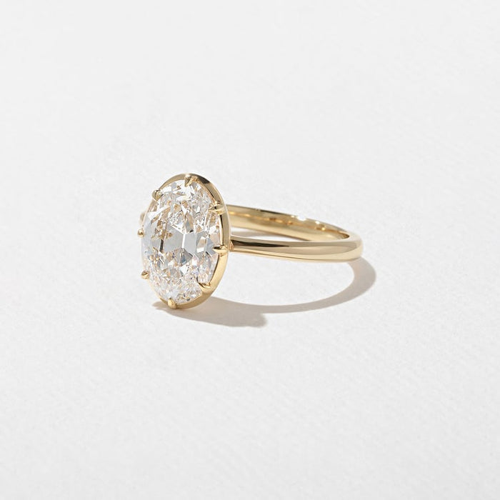 Antique oval cut lab grown diamond solitaire engagement ring with a decorative gallery in yellow gold