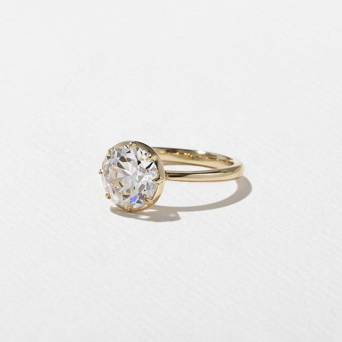 Antique round cut lab grown diamond solitaire engagement ring with a decorative gallery in yellow gold