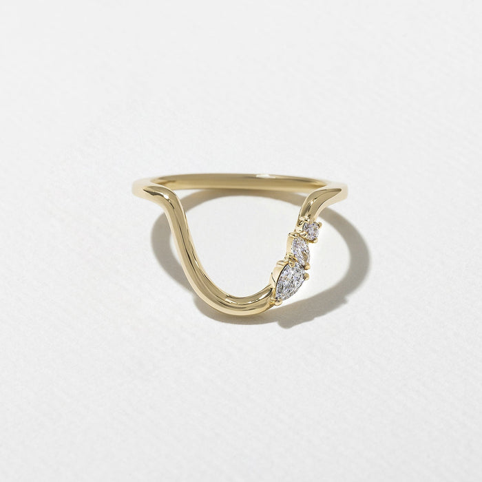 Curved three stone moissanite wedding band in yellow gold