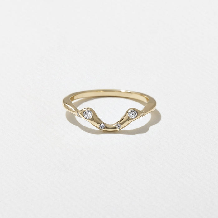 Round moissanite scattered curved wedding band in yellow gold