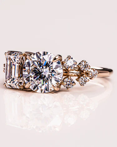 Two-stone round and emerald moissanite ring, angled view