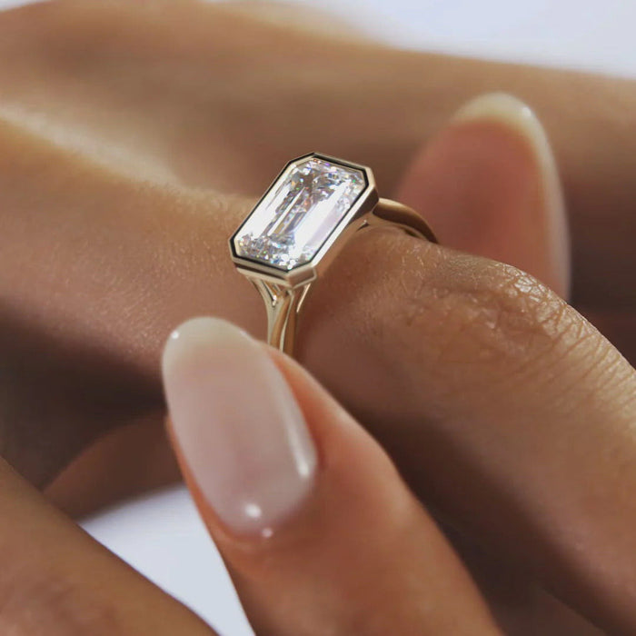 East west bezel set emerald moissanite bridal ring, angled view