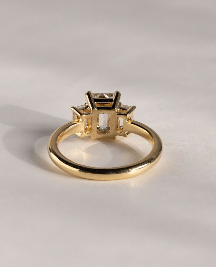 Handmade three stone emerald moissanite bridal ring, angled view