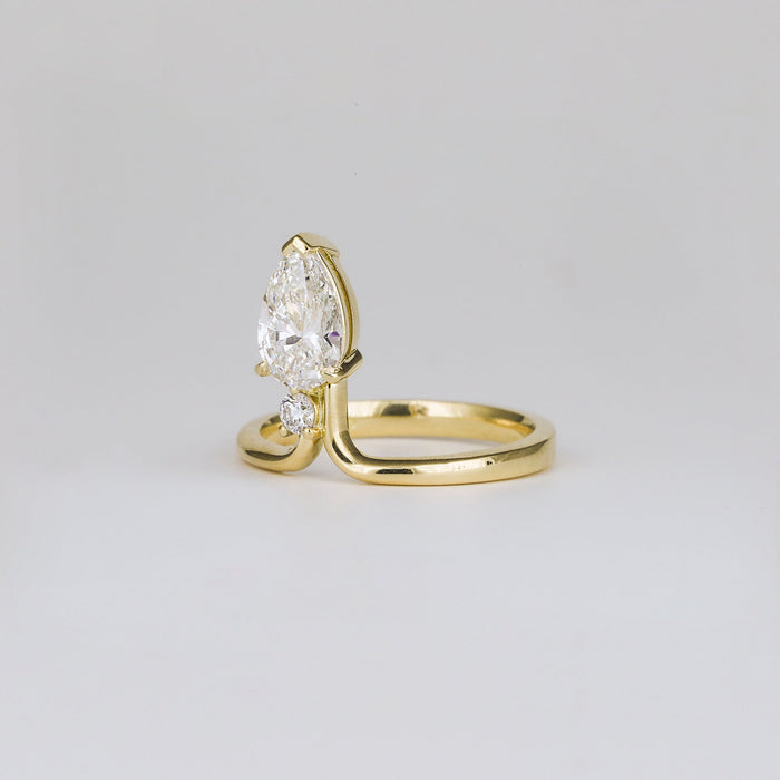 Angled view of the pear cut diamond above the round accent