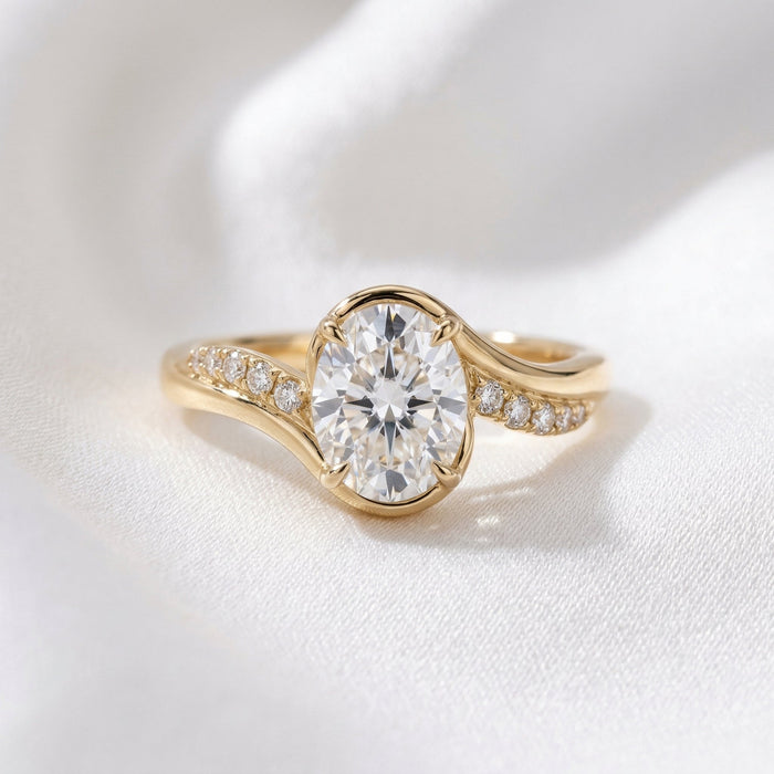 Oval cut lab grown diamond half bezel ring on a crossover pave band in yellow gold