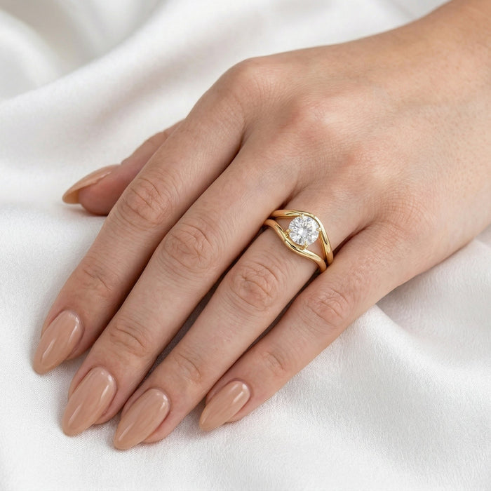 Split shank ring worn on the hand on white fabric