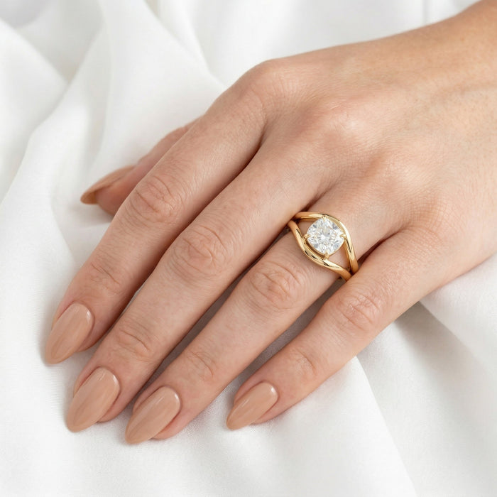Split shank cushion ring worn on the hand on white fabric