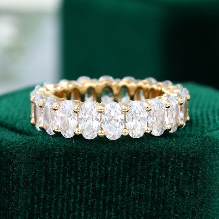 Front view of an oval moissanite prong set full eternity wedding band in yellow gold