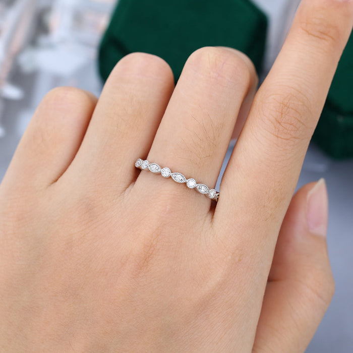 Round moissanite milgrain vintage wedding band in white gold worn on the finger