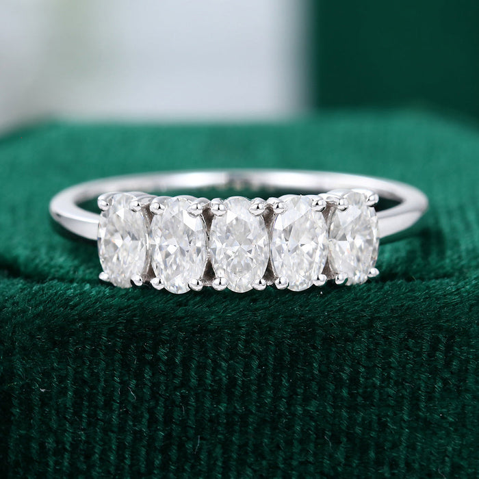Front view of an oval moissanite five stone anniversary wedding band in white gold