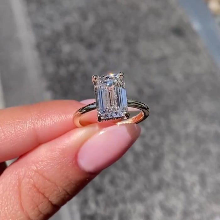 Handmade emerald cut moissanite bridal ring, angled view