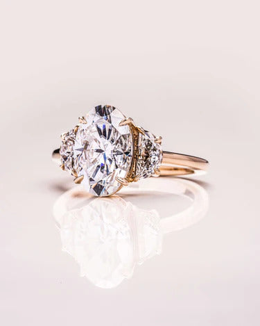 Handmade trilogy oval cut moissanite wedding ring, angled view