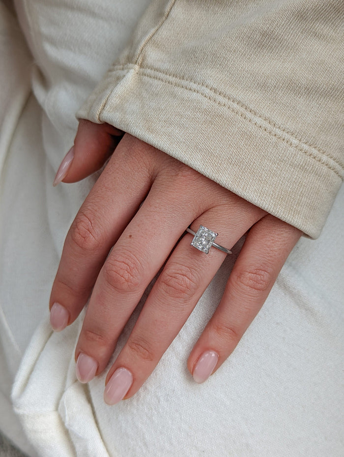Cushion cut lab grown diamond engagement ring on the finger