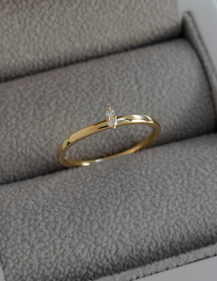 Slim gold stacking ring with two small round moissanite in a ring box