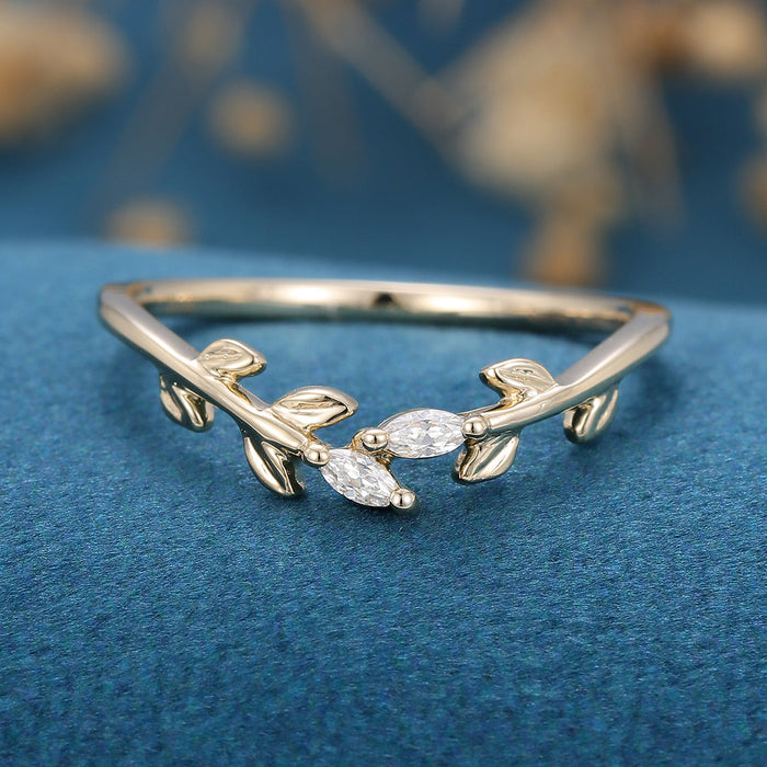 Front view of a leaf vine wedding band with two marquise moissanite stones in yellow gold