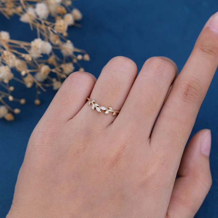 Marquise moissanite leaf vine nature inspired wedding band in yellow gold worn on a finger