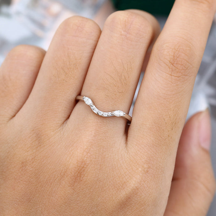 Marquise and round moissanite curved wedding band worn on a finger