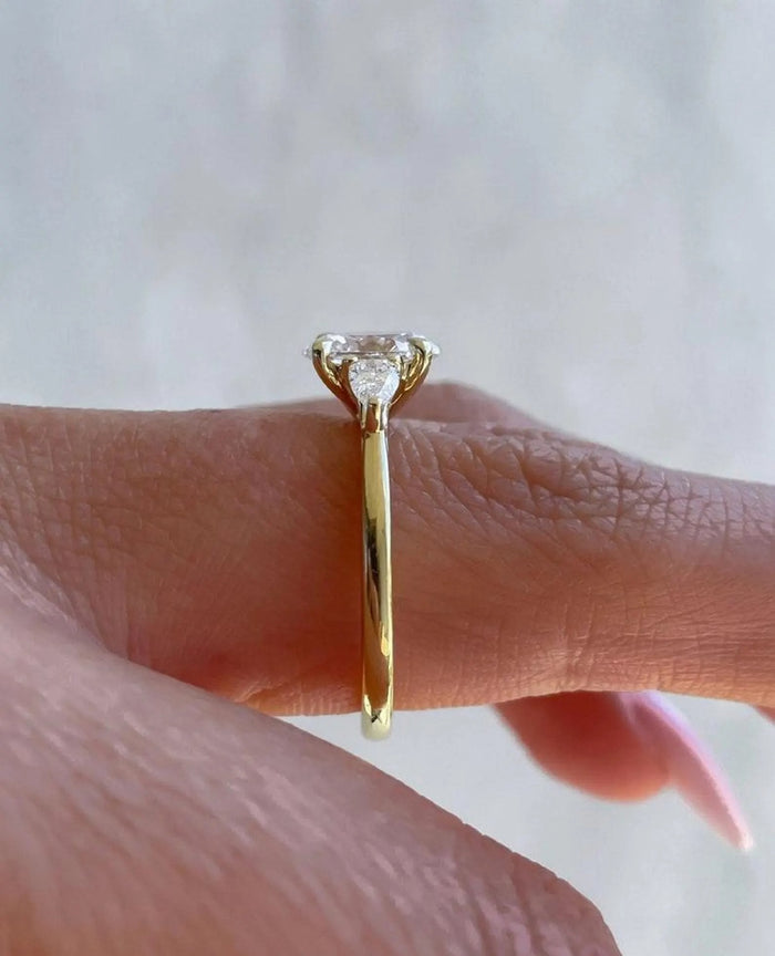 Oval cut lab grown diamond three stone ring, angled view