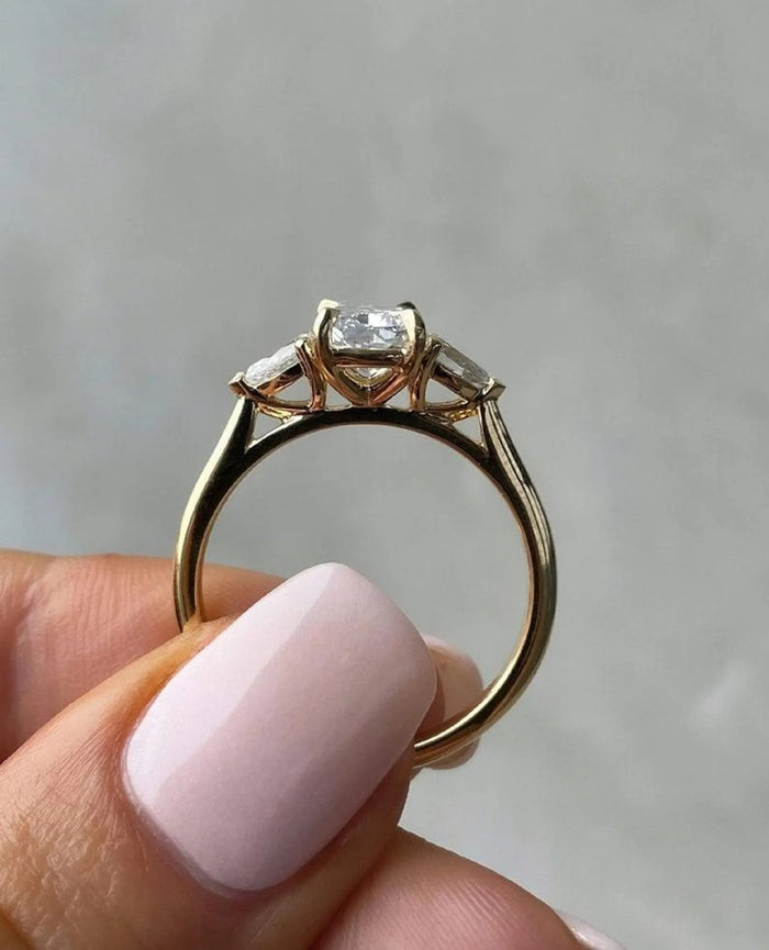 Profile of the cushion cut three stone ring with trillion accents