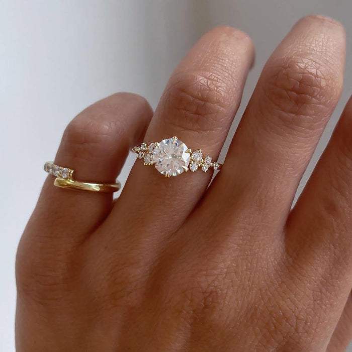 Round lab grown diamond in six prong head with organic accent clusters on the shoulders