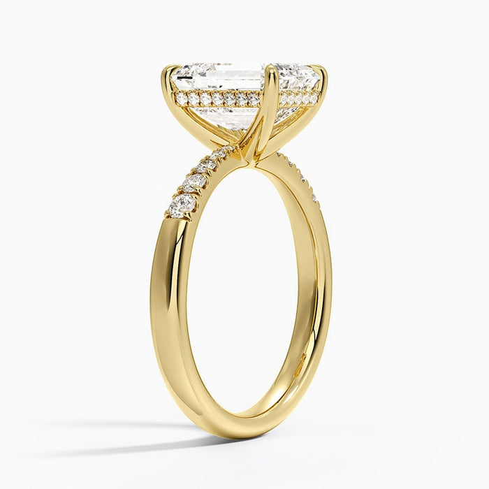 Profile view showing the hidden halo of small diamonds under the emerald cut stone