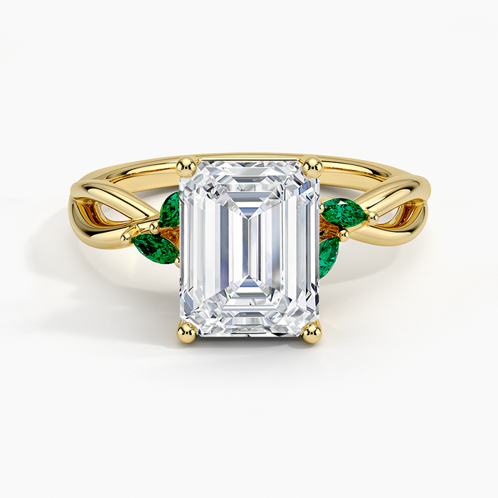 Emerald cut lab grown diamond ring in yellow gold with four marquise green emerald leaves, top view