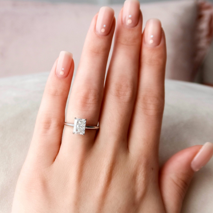 Radiant cut lab grown diamond engagement ring worn on the finger