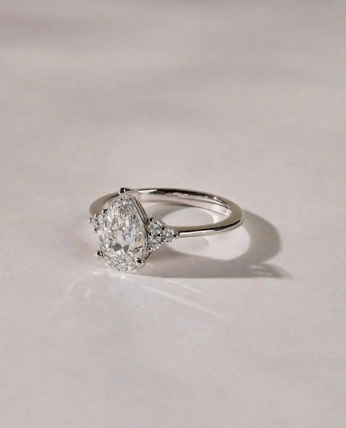Pear cut centre stone flanked by two trillion cut side stones
