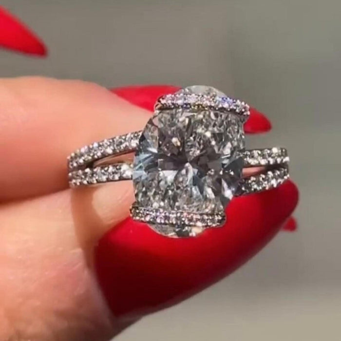 Split shank arms wrapping around the basket of the oval lab grown diamond