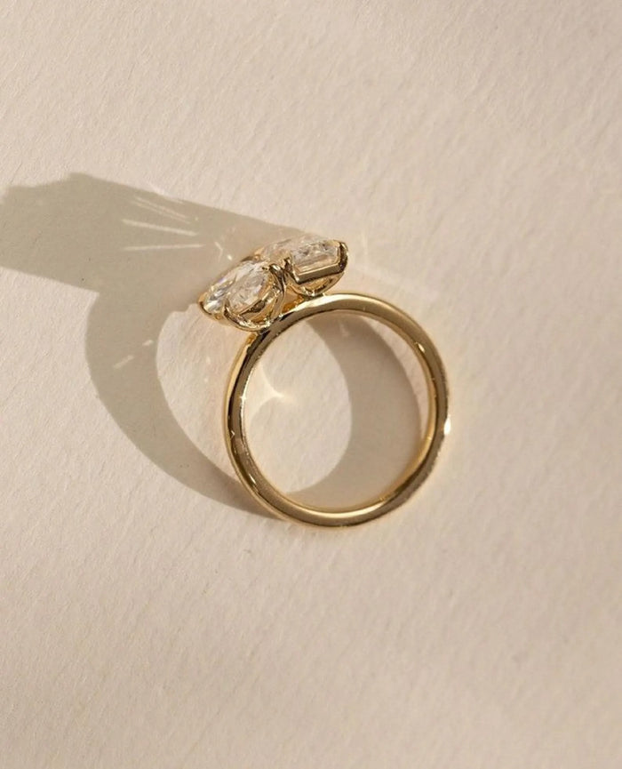 Two stone toi et moi ring with oval and emerald cut diamonds side by side
