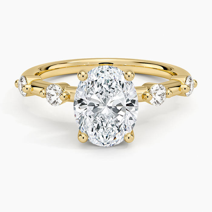 Oval cut lab grown diamond ring with spaced shared prong diamond accents in yellow gold, top view