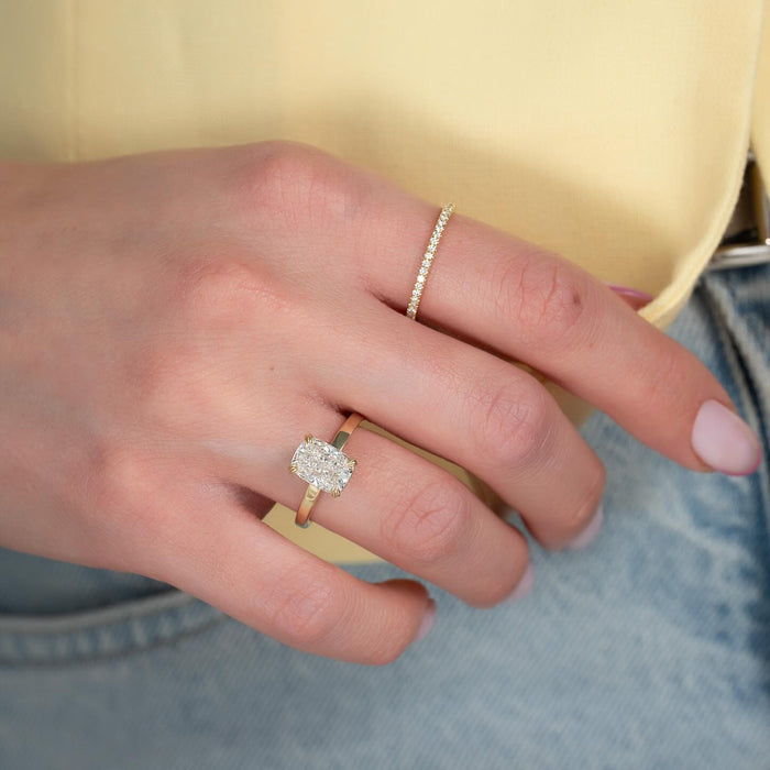 Elongated cushion lab grown diamond hidden halo ring worn on hand with a pave wedding band