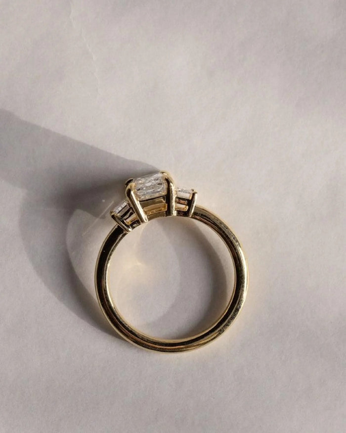 Profile of the emerald cut three stone ring with matching step cut sides