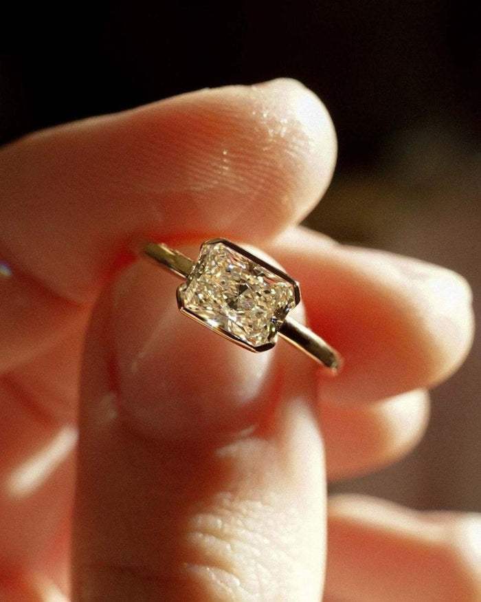 Half bezel wrapping the ends of the east west radiant lab grown diamond