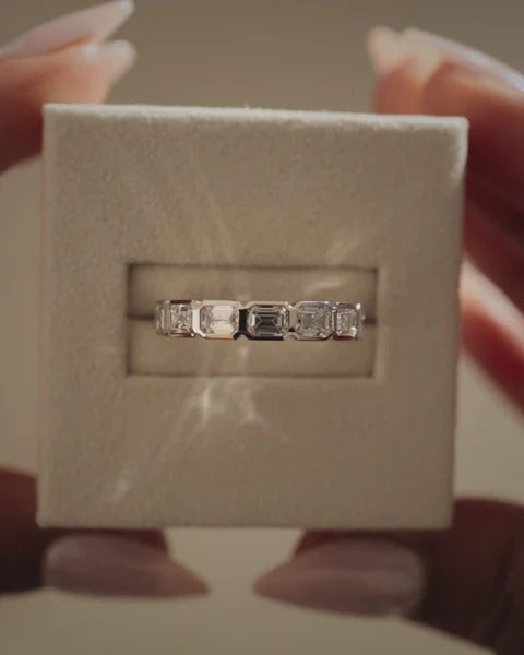 Bezel set emerald cut diamond wedding ring east west