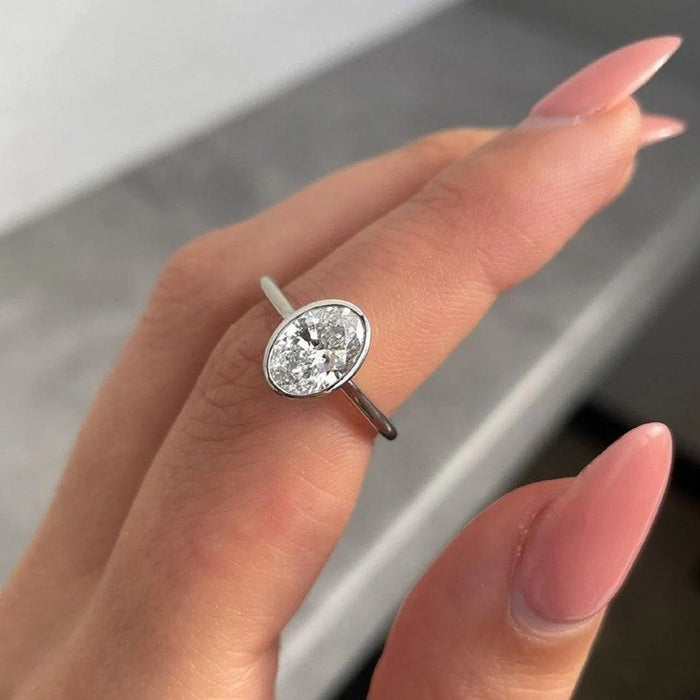 Oval cut lab grown diamond in a full bezel on a slim plain band