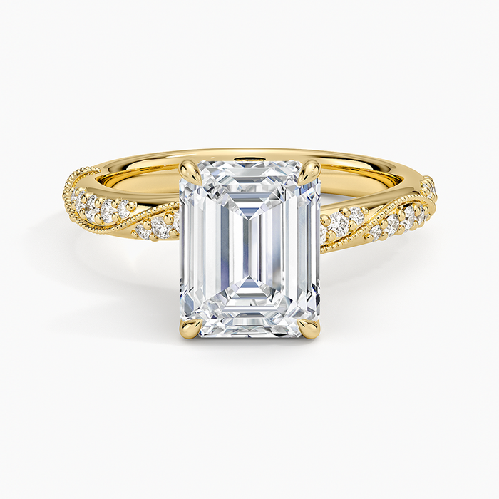 Emerald cut lab grown diamond ring in yellow gold with milgrain edged pave on a twisting band, top view