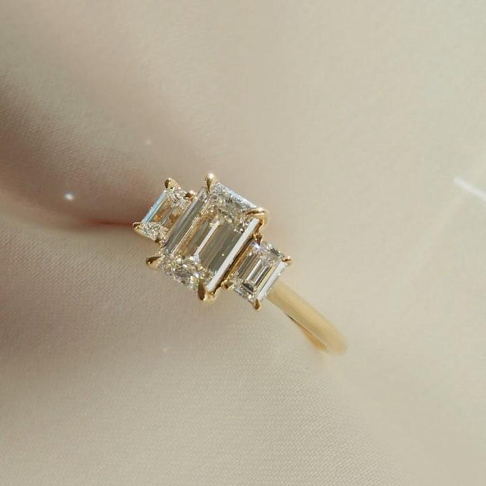 Emerald cut lab grown diamond three stone ring side profile with prong set side stones