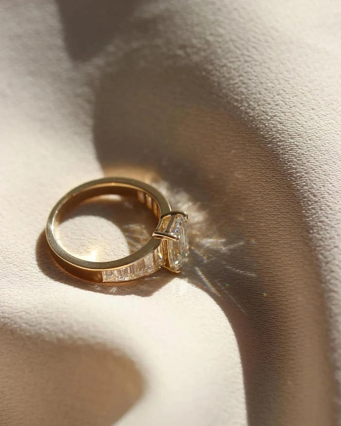 Profile of the emerald cut ring showing the channel set baguettes along the shoulder