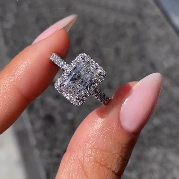 Halo of round accents framing the radiant cut lab grown diamond