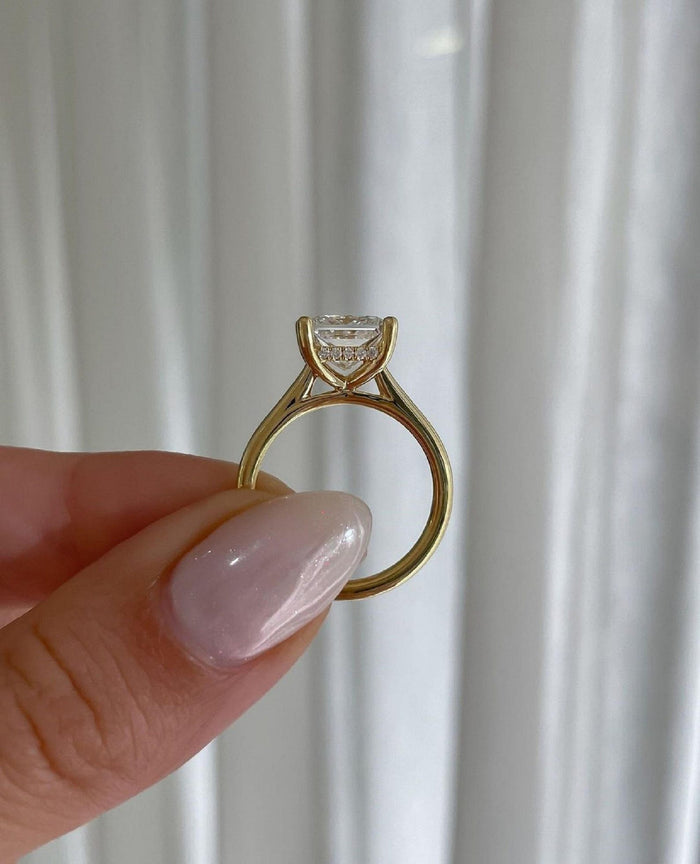 Side profile showing the cathedral shoulders and hidden halo beneath the princess cut diamond