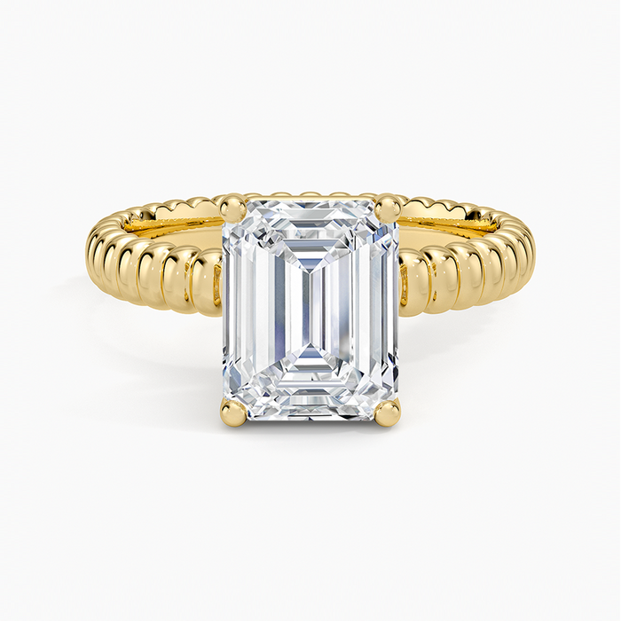 Emerald cut lab grown diamond solitaire ring in yellow gold on a ribbed coil band, top view